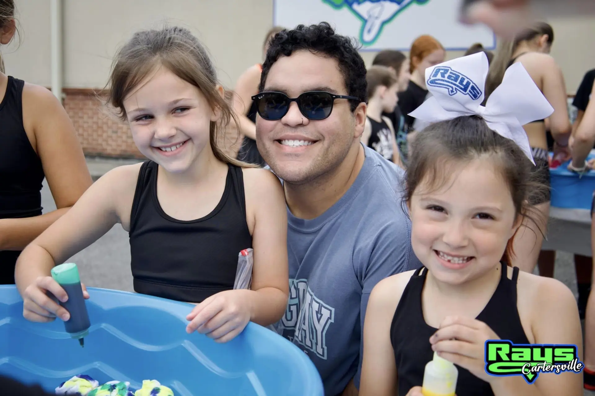 Two young children and an adult participating in a camp.